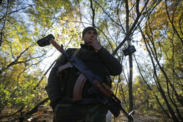 Quân nhân Ukraine đứng hút thuốc, nghe đài tại một trạm kiểm soát ở thị trấn Popasna, miền đông Ukraine.