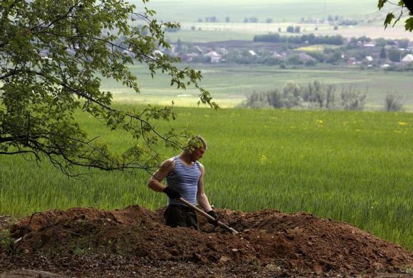 Một binh sĩ Ukraine đào hào bên ngoài một ngôi làng gần thành phố miền đông Slaviansk.