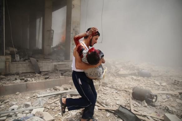 Người đàn ông bế một em bé bị thương trong một vụ đánh bom xe hơi tại khu chợ ở Damascus, Syria.