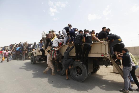 Thanh niên tình nguyện gia nhập quân đội Iraq chống lại phiến quân Hồi giáo, lên các xe tải quân sự ở thủ đô Baghdad.