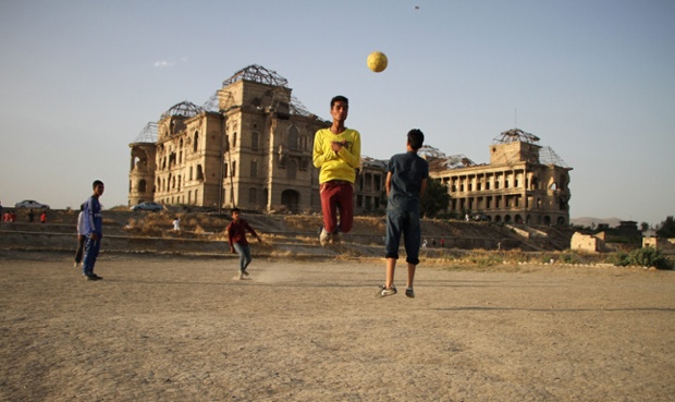 Các cậu bé chơi bóng đá cạnh cung điện Dar-ul-Aman bị tàn phá bởi chiến tranh ở ngoại ô Kabul, Afghanistan.