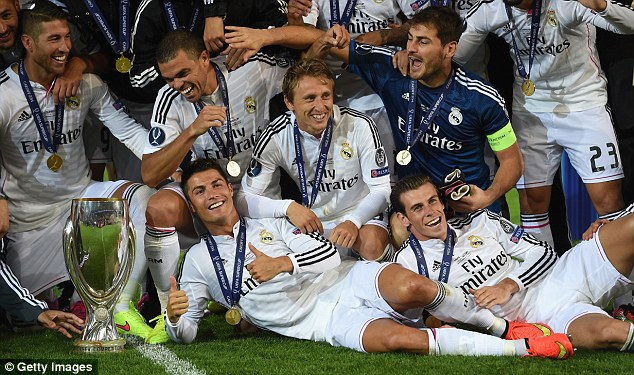 Thumbs up from us: Ronaldo lays alongside Bale next to the Super Cup trophy as Luka Modric (centre) looks on