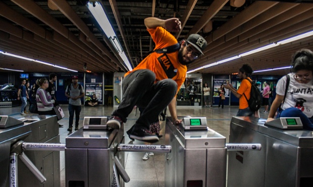 Mọi người nhảy qua rào chắn trong cuộc đình công của nhân viên tàu điện ngầm ở Sao Paulo, Brazil.