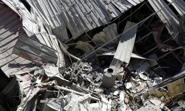 Người đàn ông kiểm tra thiệt hại sau vụ không kích của quân đội Israel nhằm vào thành phố Gaza.