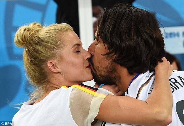 Happy: Khedira shares a kiss with his girlfriend Gercke after receiving his World Cup winners medal