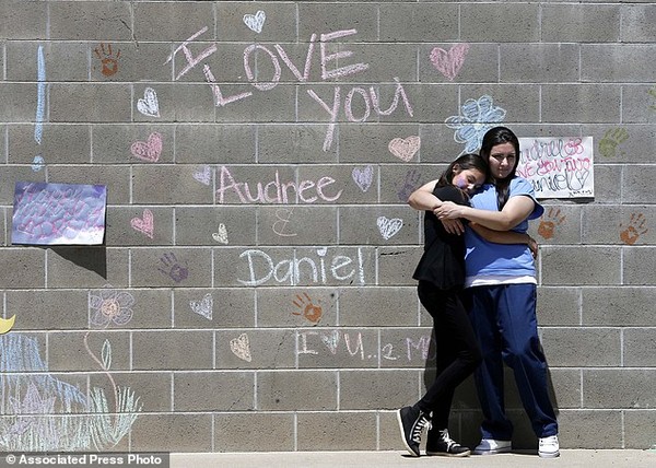 Audree Loaiza, 11 tuổi, ôm mẹ - nữ tù nhân Andrea Fabbri bên cạnh bức tường có viết dòng chữ yêu thương mà 2 mẹ con dành cho nhau.