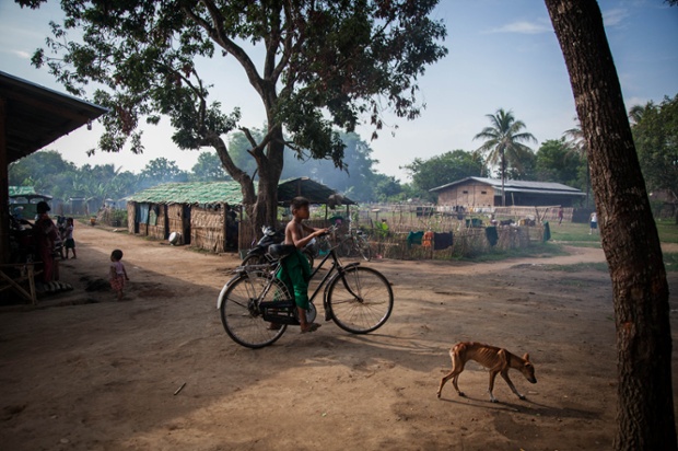 Một cậu bé đạp xe qua trại tị nạn ở Myitkyina, Myanmar.