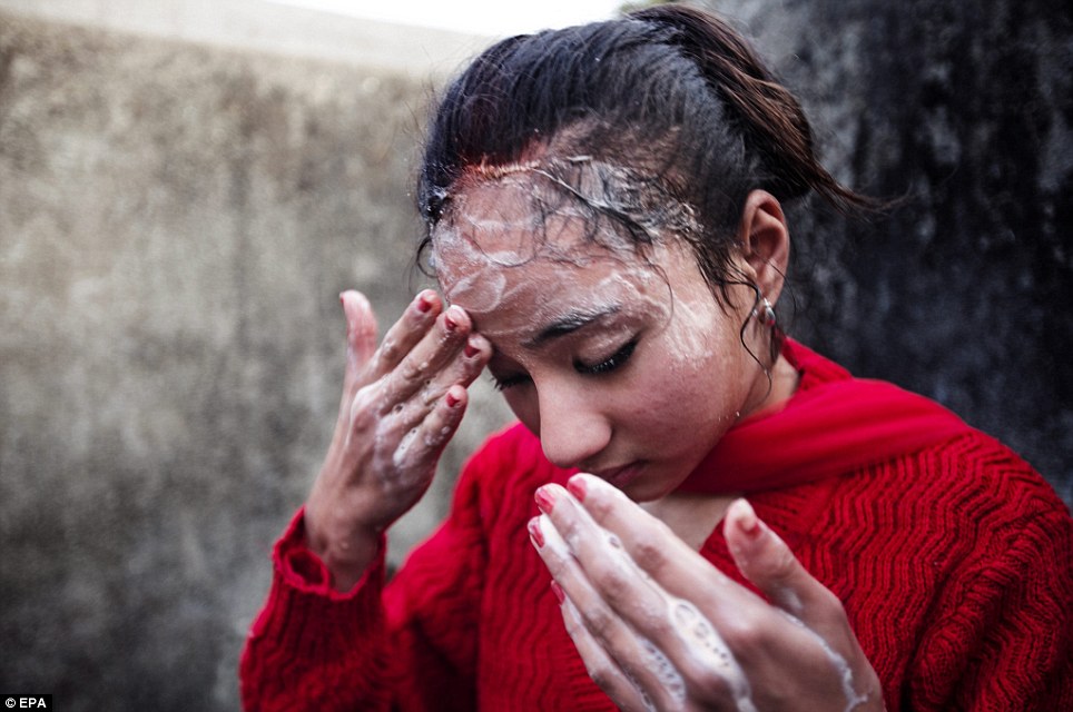 Kumari Samita Bajracharya rửa mắt thứ ba của mình tại sông Bagmati trong Patan, Nepal, ngày 07 tháng ba năm 2014. Sau khi hoàn thành 12 ngày lễ Gufa, ngày hôm sau Kumari đi vào con sông gần đó và cởi tóc và rửa con mắt thứ ba vẽ được thực hiện trên trán cô.  Nghi lễ này là mục tiêu của Samita như một Kumari