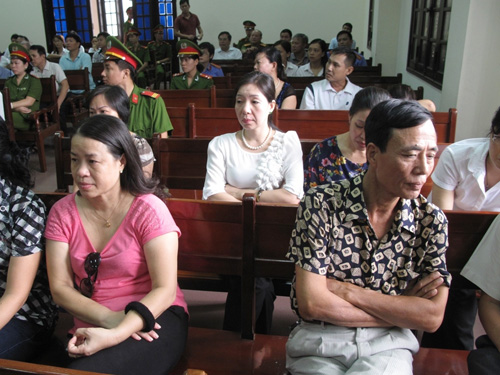 Bà Phạm Thị Thanh Hằng (áo trắng) ngồi bất động nhìn chồng