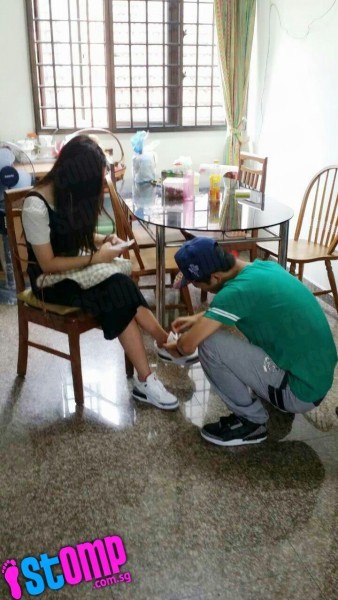 Chàng trai buộc dây giày cho người yêu trong khi cô gái 