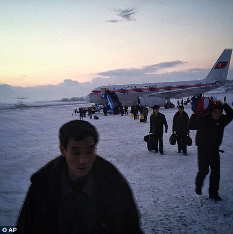 Hành khách đi bộ qua đường băng tuyết tại sân bay Bình Nhưỡng như một chuyến bay Air Koryo đến từ Bắc Kinh