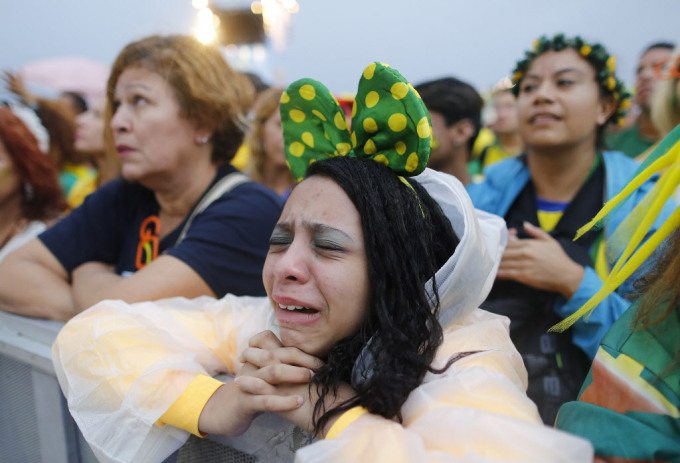 Một fan hâm mộ bóng đá Brazil phản ứng trong thất vọng khi bà nhìn thấy nhóm của cô chơi một trận bán kết World Cup với Đức trên truyền hình trực tiếp trong khu vực FIFA Fan Fest trên bãi biển Copacabana ở Rio de Janeiro, Brazil, Thứ Ba 8 tháng 7, năm 2014. (AP Photo / Leo Correa)