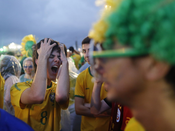 Một fan hâm mộ bóng đá Brazil phản ứng trong thất vọng khi nhìn đội bóng của ông chơi một trận bán kết World Cup với Đức trên truyền hình trực tiếp trong khu vực FIFA Fan Fest trên bãi biển Copacabana ở Rio de Janeiro, Brazil, thứ Ba 8 tháng 7, 2014. (AP Photo / Leo Correa) 