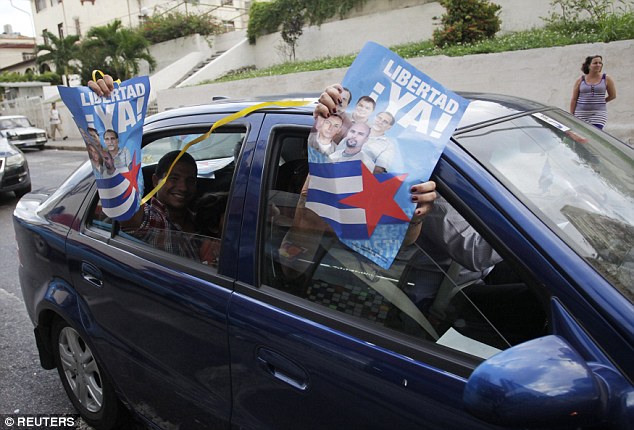 Những người dân địa phương trên một chiếc ô tô con cũng giơ cao các tấm poster chúc mừng nhóm 5 công dân Mỹ.