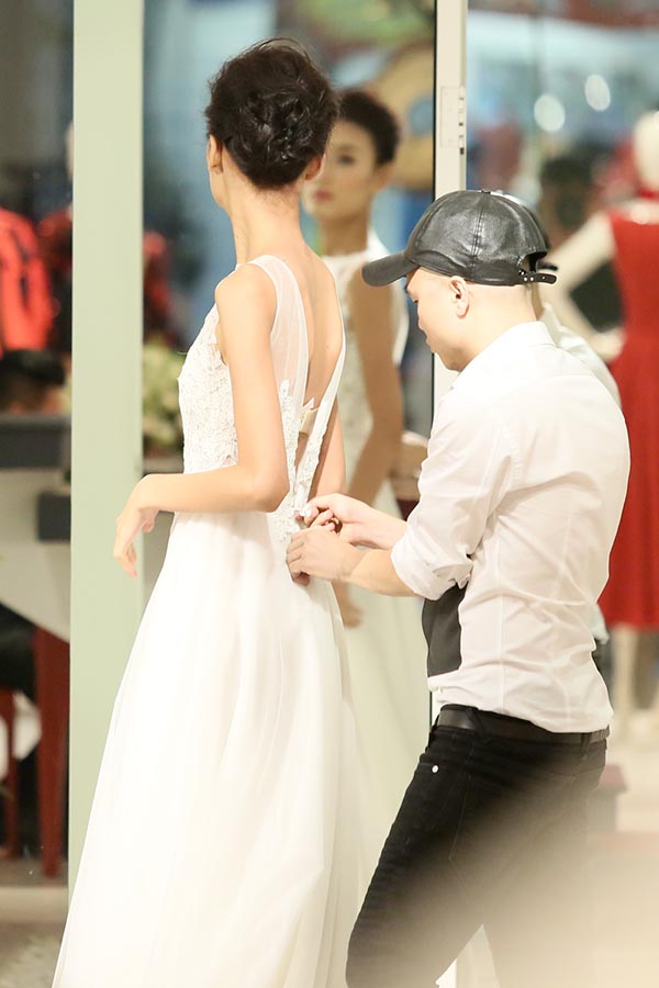 Ngay khi có mặt, Lê Thuý được NTK Đỗ Mạnh Cường cho mặc thử chiếc váy cưới được thiết kế riêng.