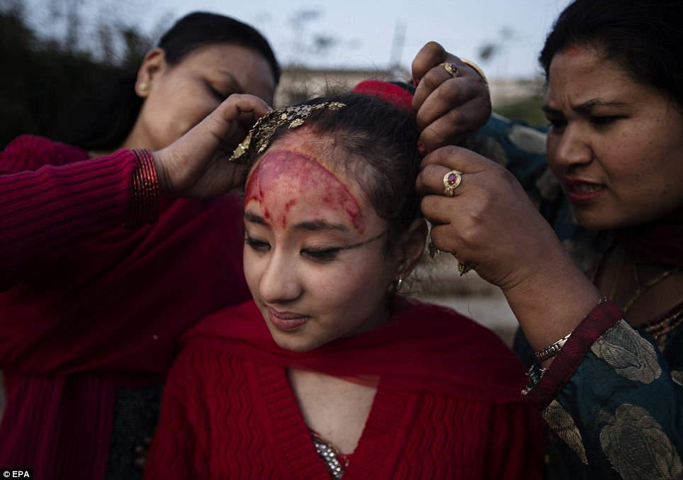 Mẹ Purna Shova, trái, cởi tóc của Kumari Samita Bajracharya, trung tâm, sau khi hoàn thành 12 ngày lễ Gufa, tại sông Bagmati trong Patan, Nepal, ngày 07 Tháng Ba 2014