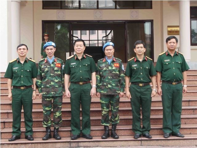 Trung tướng Nguyễn Trọng Nghĩa chụp ảnh lưu niệm với hai sĩ quan tham gia lực lượng gìn giữ hòa bình LHQ và cán bộ Trung tâm gìn giữ hòa bình Việt Nam.