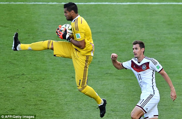 Commanding: Sergio Romero takes the ball with Miroslav Klose (right) in attendance