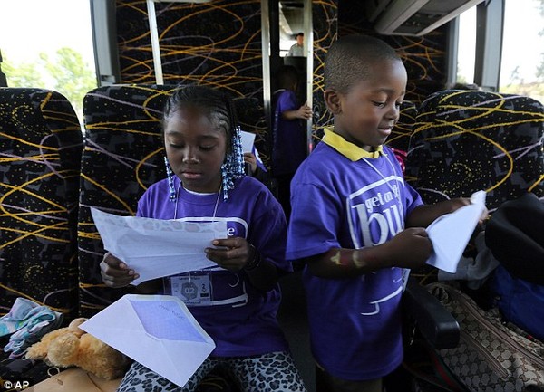 Lamariae Williams, 10 tuổi cùng em trai Taryn Mitchell đang xem thư mẹ gửi trên chiếc xe buýt đưa 2 em về nhà sau khi được gặp mẹ.