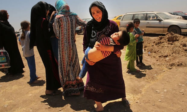 Bà mẹ người Iraq bế đứa con trai đã kiệt sức, đứng chờ với hy vọng có thể vào một trại tị nạn gần thành phố Mosul.