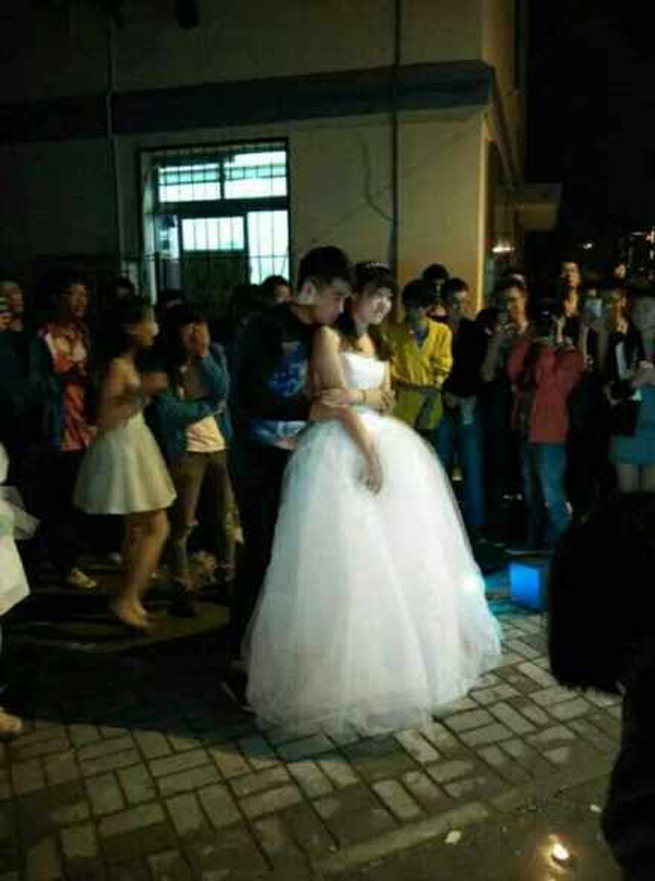 Nữ sinh mặc váy cưới đứng dưới ký túc xá cầu hôn bạn trai