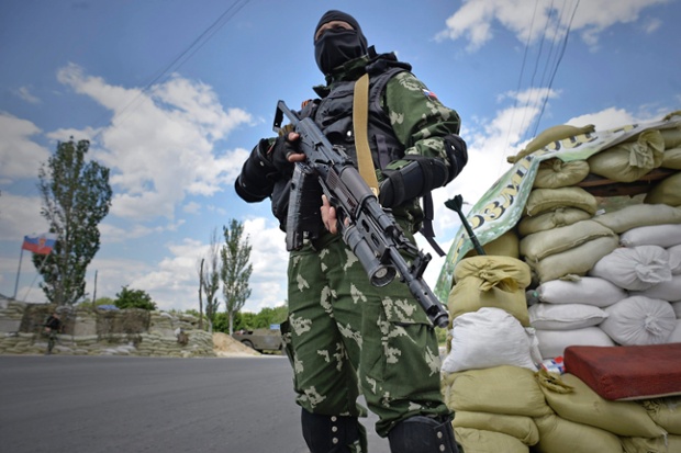 Chiến binh vũ trang thân Nga đứng bảo vệ một chốt kiểm tra ở ngoại ô Donetsk, Ukraine.