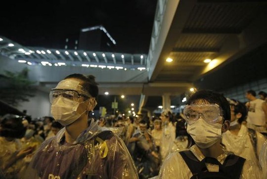 Người biểu tình tự bảo vệ trước hơi cay của cảnh sát. Ảnh: AP