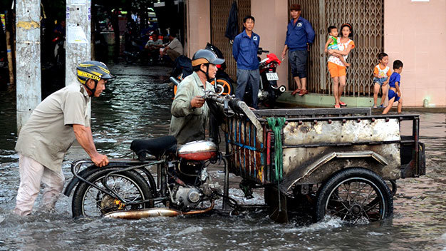 Người dân vất vả di chuyển qua đoạn đường ngập - Ảnh: Thanh Tùng