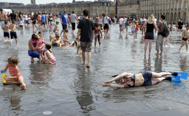 Mọi người thích thú chơi với nước trong một ngày nắng nóng tại trung tâm Bordeaux, Pháp.