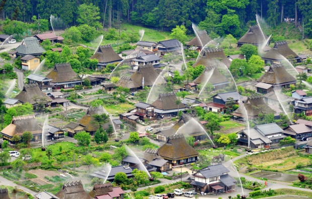 Nước được phun lên các ngôi nhà lợp mái rạ trong cuộc diễn tập phòng cháy ở Kayabuki no Sato, Kyoto, Nhật Bản.