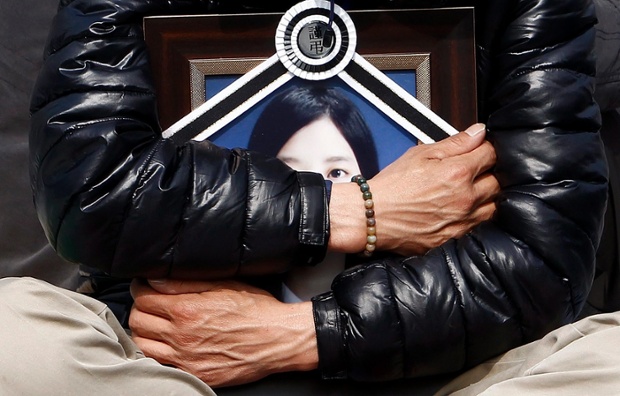 Một người đàn ông ôm ảnh con gái thiệt mạng trong vụ chìm phà Sewol, tham gia biểu tình trước văn phòng tổng thống ở Seoul, Hàn Quốc.