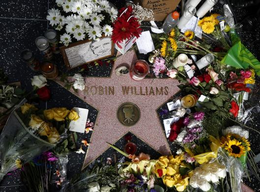 Người dân đặt hoa tưởng nhớ diễn viên Robin William vừa mất tại ngôi sao ghi tên ông trên Đại lộ Hollywood, Los Angeles, Mỹ. 