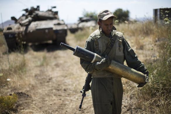 Một binh sĩ Israel mang đạn pháo xe tăng trên Cao nguyên Golan, khu vực ngừng bắn giữa Israel và Syria.