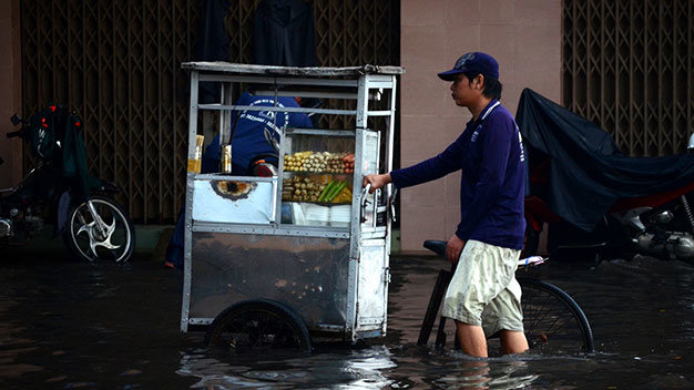 Người dân vất vả di chuyển qua đoạn đường ngập - Ảnh: Thanh Tùng