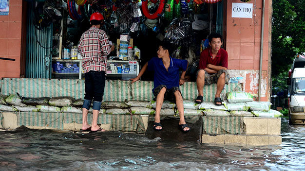 Một tiệm sửa xe phải xây rào chắn ngăn không cho nước tràn vào nhà - Ảnh: Thanh Tùng