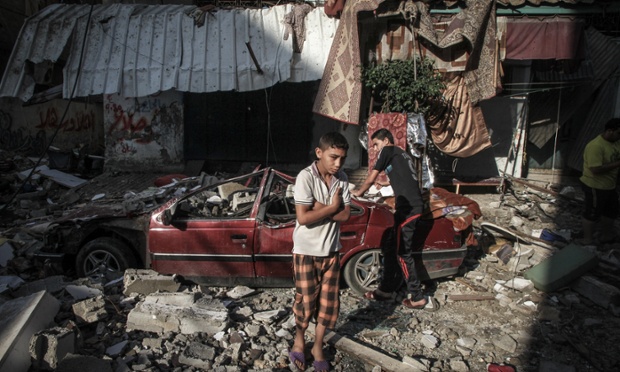 Hai cậu bé người Palestine đứng cạnh hiện trường vụ không kích của quân đội Israel tại Dải Gaza. Ít nhất Palestine đã thiệt mạng trong các đợt không kích của Israel suốt 3 ngày qua.