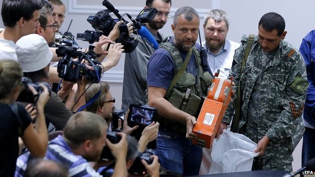 Một lãnh đạo cấp cao của phe ly khai ở miền đông Ukraine trao hộp đen của chiếc máy bay MH17 cho đại diện của Malaysia.