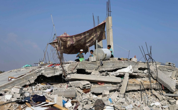Trẻ em người Palestine ngồi trên đỉnh đống đổ nát của một ngôi nhà bị phá hủy trong cuộc không kích của quân đội Israel nhằm vào thành phố Gaza.
