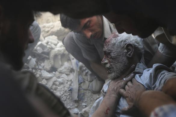 Người dân đưa một nạn nhân bị thương khỏi hiện trường vụ không kích bởi quân đội chính phủ ở thành phố Douma, Syria.