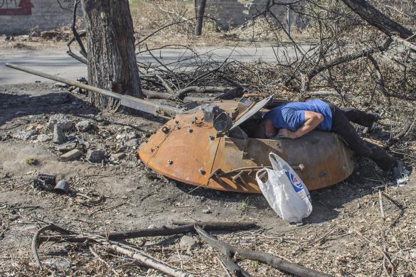 Người đàn ông kiểm tra bên trong tháp pháo của một phương tiện bọc thép chở quân Ukraine bị phá hủy tại ngôi làng Lutugine, ngoại ô thành phố Luhansk.