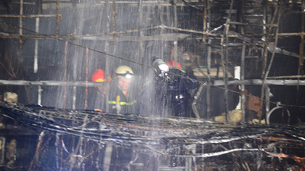 Lính cứu hỏa tiếp cận ngôi nhà bị cháy - Ảnh: Quang Định