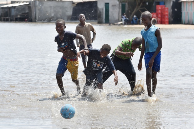 Các cậu bé chơi bóng đá trên đường phố ngập lụt sau nhiều ngày mưa lớn tại thành phố Abidjan, Bờ Biển Ngà.