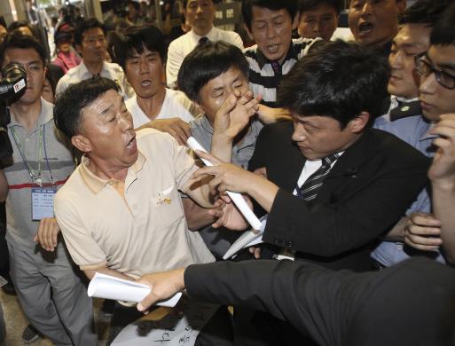 Thân nhân của hành khách trên phà Sewol bị nhân viên an ninh chặn, khi cố gắng tham dự phiên tòa xét xử các thủy thủ đoàn của phà tại tòa án Gwangju, Hàn Quốc.