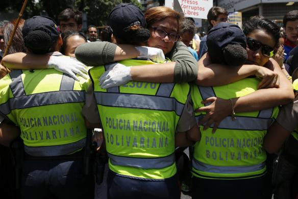 Người biểu tình chống chính phủ ôm cảnh sát ở Caracas, Venezuela.