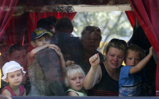 Người dân ở thành phố Donetsk, Ukraine, trên một chuyến xe bus chuẩn bị sơ tán Nga để tránh các cuộc giao tranh giữa các tay súng ly khai và quân đội chính phủ.