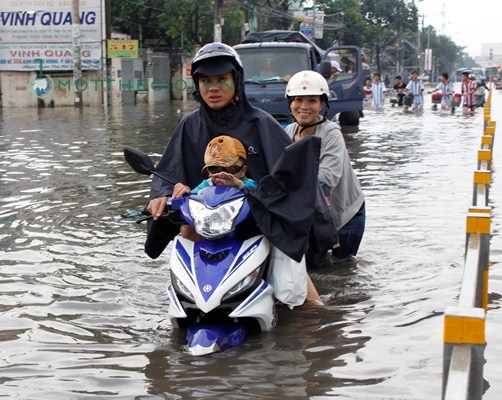 Vợ chồng chị Nguyễn Thị Thanh vừa đón con đi học về bì bõm dắt bộ