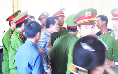 Lực lượng công an lao vào ngăn cản Lê Minh Phát khi bị cáo này đạp ghế phản đối. Ảnh: TẤN LỘC