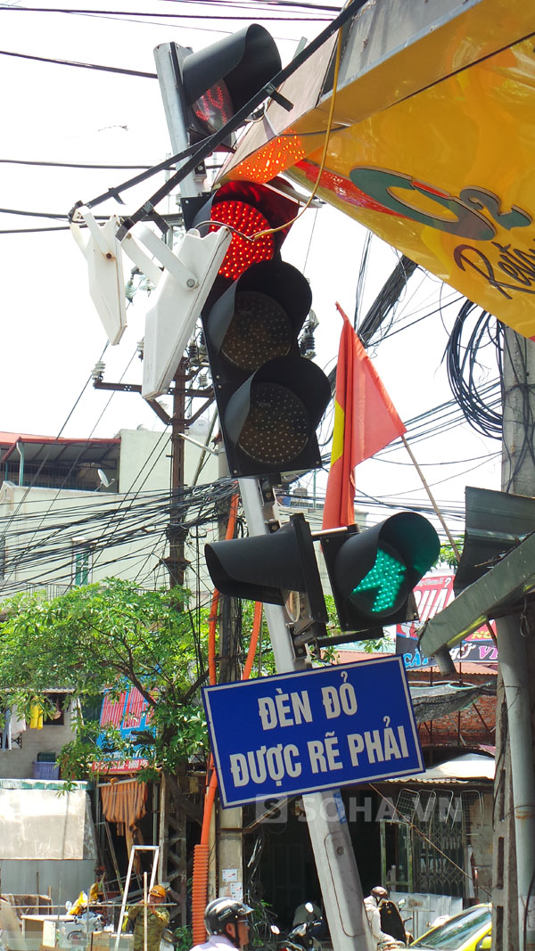 Cột đèn tín hiệu giao thông nằm ngay ngã tư Nguyễn Phong Sắc - Tô Hiệu bị mái hiên đè lên gần đổ hoàn toàn.