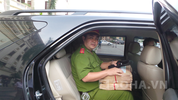 Đại úy Đỗ Quang đang ôm chặt túi đề thi đưa đi địa điểm thi khác