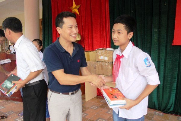 Nhà báo Bùi Ngọc Hải trao tặng trực tiếp cuốn sách cho học sinh.